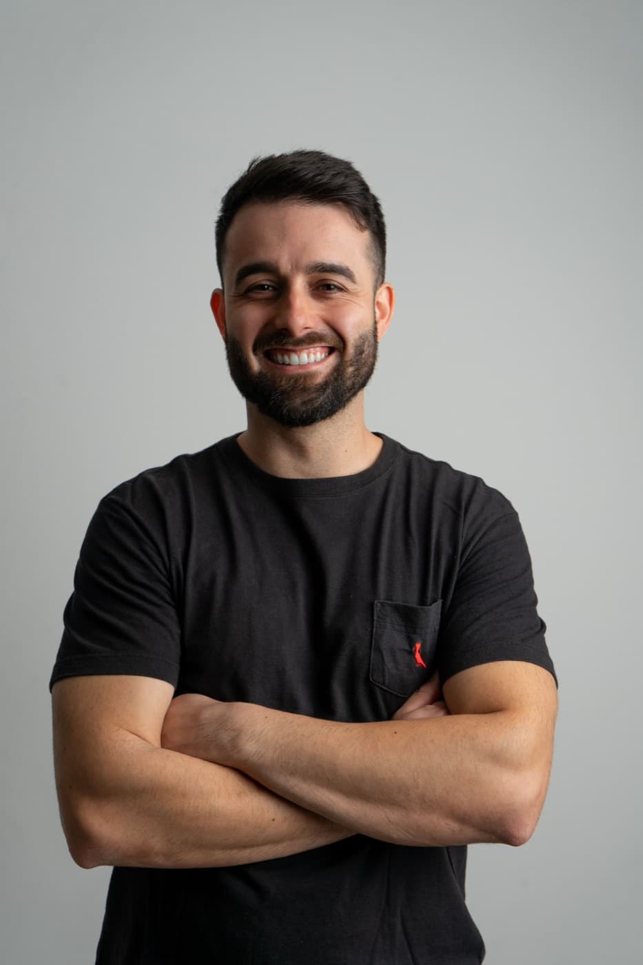 A smiling Italian tutor, arms crossed